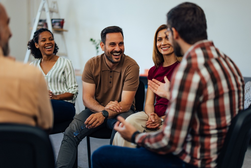 a group of individuals laughing in therapy