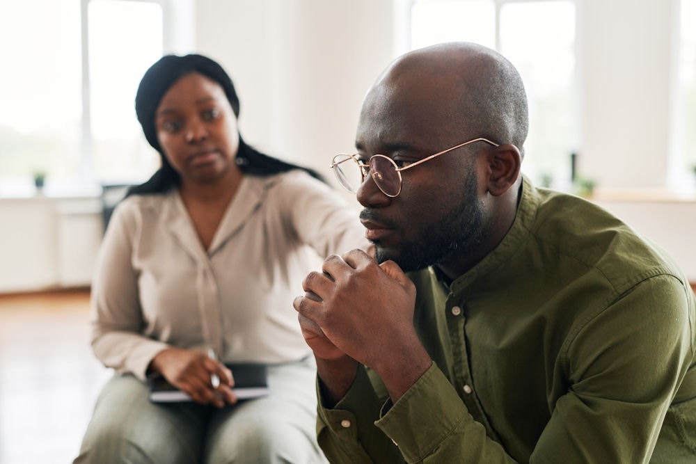 a man being comforted in cbt for alcohol use disorder