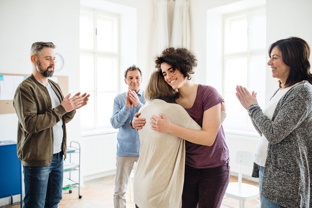 a-woman-being-hugged-in-group-therapy