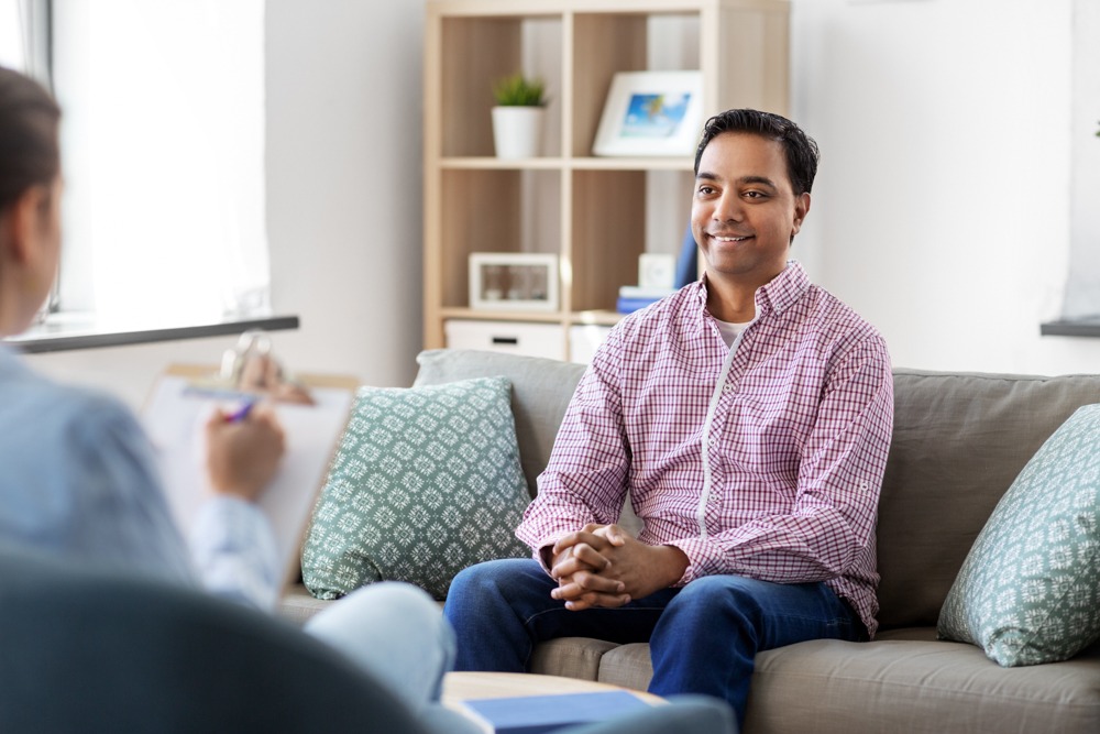 a man smiling in individual therapy